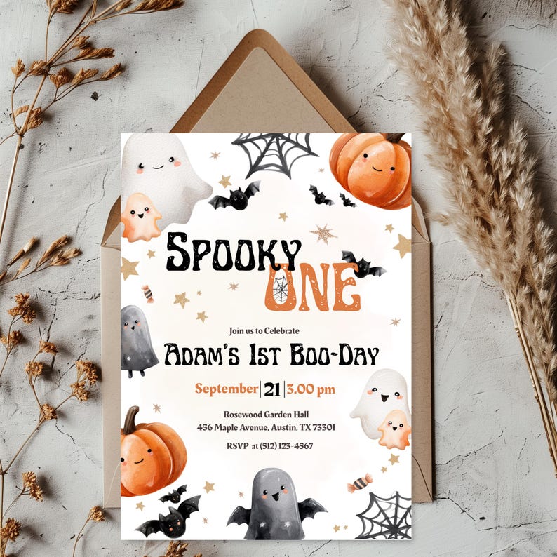 May include: A Halloween-themed invitation card featuring the text "SPOOKY ONE" and "Adam's 1st Boo-Day." The design incorporates illustrations of ghosts, pumpkins, bats, and spiderwebs. The invitation is set against a neutral background with decorative elements.