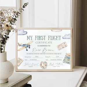 Può includere: Certificato incorniciato "Il Mio Primo Volo" con un design ad acquerello di un aereo, nuvole e bagagli. Il certificato è assegnato a "Eric Brown" e include i dettagli del volo, un passaporto e una carta d'imbarco.