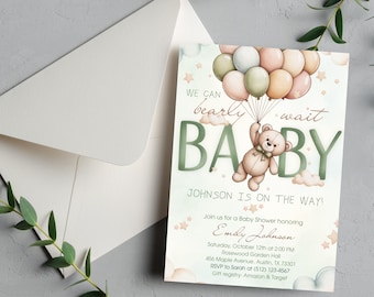 Puede incluir: Invitación a un baby shower con un osito de peluche sosteniendo globos. El texto dice "We can bearly wait BABY" con detalles del evento. Un sobre y vegetación en el fondo.