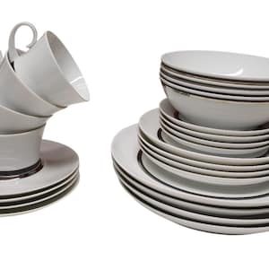 Puede incluir: Un juego de vajilla de cerámica blanca, que incluye tazas, platillos, cuencos y platos. Las tazas están apiladas y los platos y cuencos están dispuestos en pilas separadas. Cada pieza tiene una banda oscura alrededor del borde.