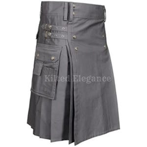Op de afbeelding: Een grijze kilt met plooien, zakken en gespen. De kilt heeft een gestructureerd ontwerp met een voorschort en zijzakken. De tekst "Kilted Elegance" is zichtbaar op de kilt.