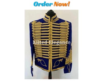 May include: A navy blue military-style jacket with gold-colored trim and decorative elements. The jacket features multiple rows of gold braid and ornate detailing on the sleeves and collar. The text "Kilted Elegance" is visible on the jacket.