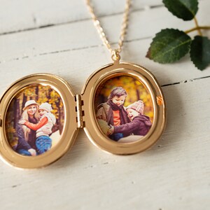 May include: Gold locket necklace with two oval photo frames. The locket is open and shows a photo of a woman and a child in the left frame and a photo of two children in the right frame.