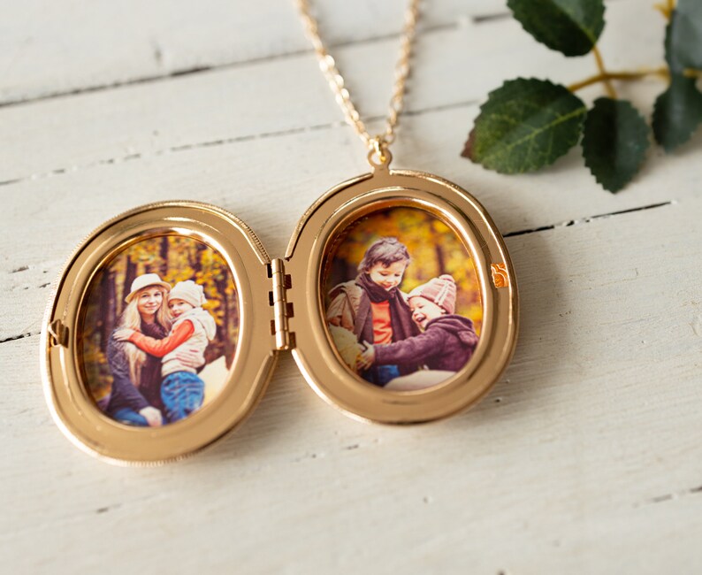 May include: Gold locket necklace with two oval photo frames. The locket is open and shows a photo of a woman and a child in the left frame and a photo of two children in the right frame.