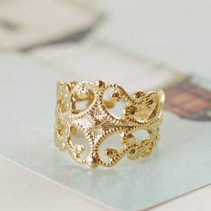 Puede incluir: Un anillo de filigrana dorado con un dise&ntilde;o delicado e intrincado. El anillo est&aacute; hecho de un metal fino y tiene un dise&ntilde;o delicado y calado.