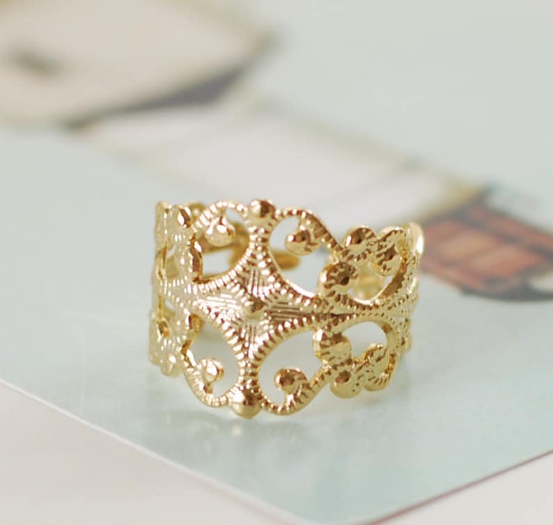 Puede incluir: Un anillo de filigrana dorado con un dise&ntilde;o delicado e intrincado. El anillo est&aacute; hecho de un metal fino y tiene un dise&ntilde;o delicado y calado.