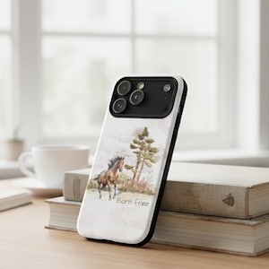 Könnte beinhalten: Eine weiße Smartphone-Hülle mit einem braunen Pferd, das auf einem Feld neben einem Kiefernbaum läuft, sowie dem in Schwarz gedruckten Text Born free. Die Hülle hat einen schwarzen Kameramodulausschnitt und schwarze Ränder mit einer Illustration.