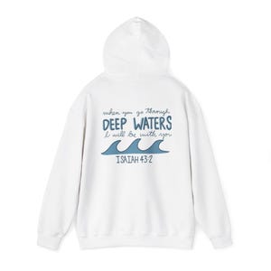 May include: A white hooded sweatshirt featuring a graphic on the back with the text "when you go through DEEP WATERS I will be with you" in blue and black script and print, accompanied by a blue wave illustration and the text "ISAIAH 43:2".