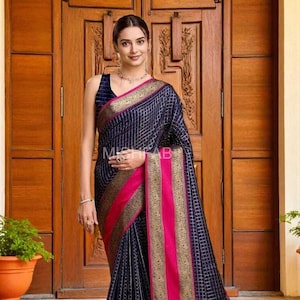 May include: A navy blue saree with a grid pattern, accented with vibrant pink and gold borders. The saree features intricate gold detailing and a decorative fringe at the hem. The image shows the saree draped on a person.