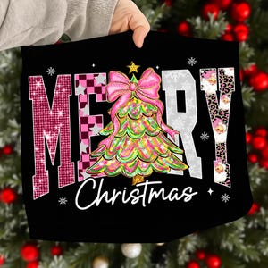 May include: Black Christmas-themed design with the words "MERRY Christmas" in a festive font. The "M" is pink with glitter, the "E" is a pink and white checkered pattern, and the "R" is white. A colorful Christmas tree and pink bow are in the center.