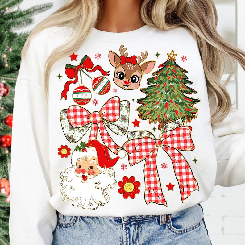 May include: White sweatshirt with a Christmas-themed design. The design features a reindeer with a red bow, a Christmas tree, Santa Claus, red and white plaid bows, baubles, and snowflakes. The graphic is colourful and detailed.