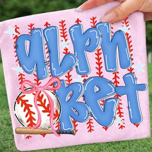 May include: A pink baseball-themed design with the word "ALPHABET" in blue bubble letters. A baseball with a pink bow and a wooden bat are featured. Red stitching and white stars complete the design.