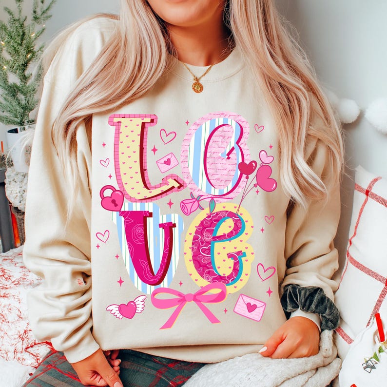 以下が含まれることがあります： カラフルな模様の「LOVE」の文字がプリントされたベージュのスウェットシャツ。ハート、南京錠、リボン、封筒のデザインで、バレンタインデーをテーマにしています。カジュアルで着心地の良いスタイルです。