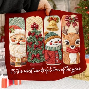 May include: Red Christmas-themed pillow with embroidered panels featuring Santa Claus, a Christmas tree, a snowman, and a reindeer. The text "it's the most wonderful time of the year" is at the bottom.