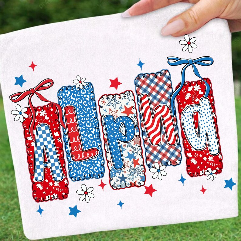 May include: White rectangular towel with the word "ALPHA" in red, white, and blue letters. Each letter has a unique pattern, including gingham, stars, and leopard print. The towel is decorated with stars, flowers, and bows.