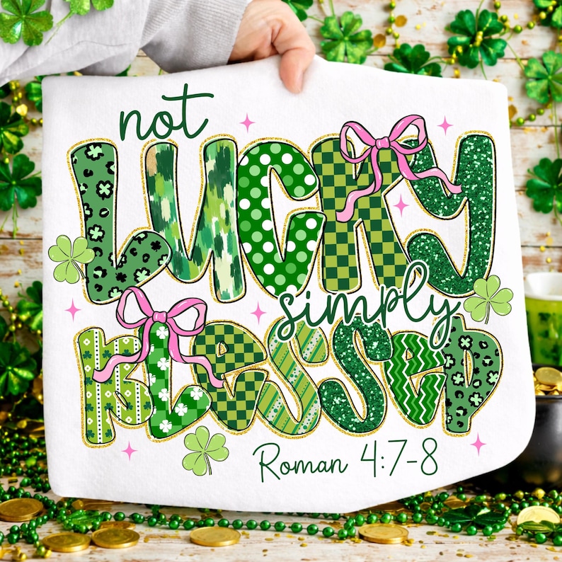 May include: White St. Patrick's Day themed towel with the words "not lucky simply blessed" in green, with pink bows and shamrock accents. The text "Roman 4:7-8" is at the bottom.