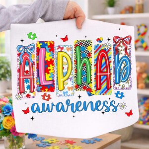 May include: White fabric featuring the word "ALPHA" in vibrant, puzzle-piece-style letters, and the word "awareness" in blue script. The design incorporates butterflies, puzzle pieces, and floral details, promoting autism awareness.