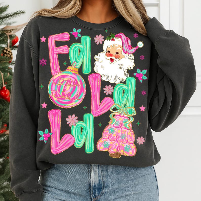 May include: Dark gray sweatshirt with a colorful Christmas graphic. The design includes the words "Fold Ld" in pink and green, a Santa Claus illustration, a Christmas ornament, and a Christmas tree.
