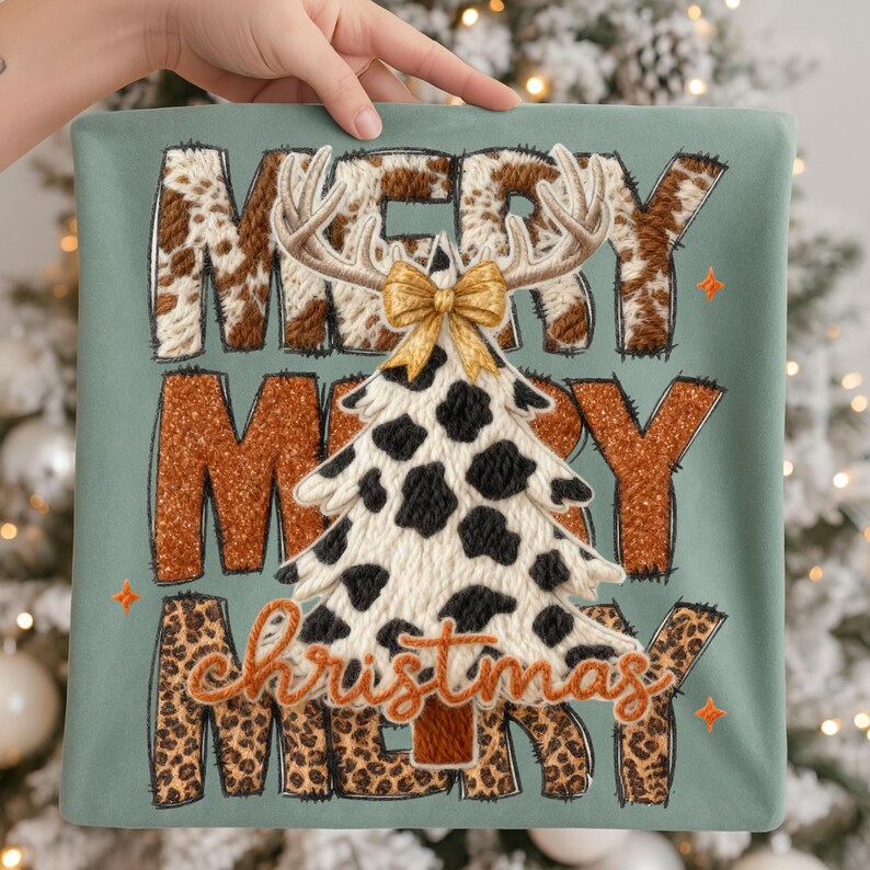 May include: A square, sage green pillow with the words "MERRY MERRY CHRISTMAS MERRY" in a mix of brown, cow print, and leopard print. A Christmas tree with cow print spots and antlers is in the center, topped with a gold bow.