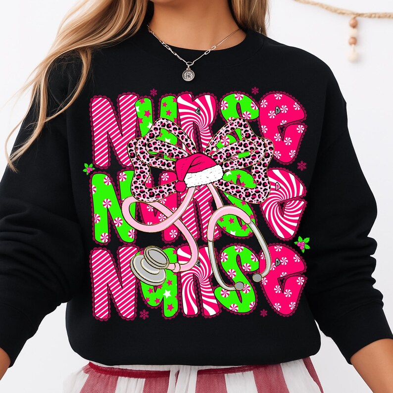 May include: Black sweatshirt with a festive design. The design features the word "NURSE" in pink and green, a leopard print bow with a Santa hat, and a pink stethoscope. The design is decorated with snowflakes.
