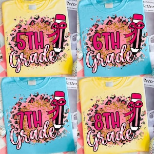 May include: Four colorful t-shirts with grade level designs. Each shirt features a grade level (5th, 6th, 7th, and 8th) in pink script, a leopard print background, and a pencil graphic with a pink bow. The shirts are yellow and blue.