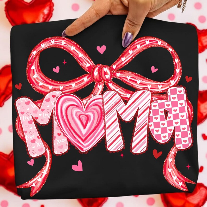 May include: Black sweatshirt with a large red bow and the word "MOM" in pink and white lettering. The "O" in "MOM" is a heart shape. Small pink hearts are scattered around the design.