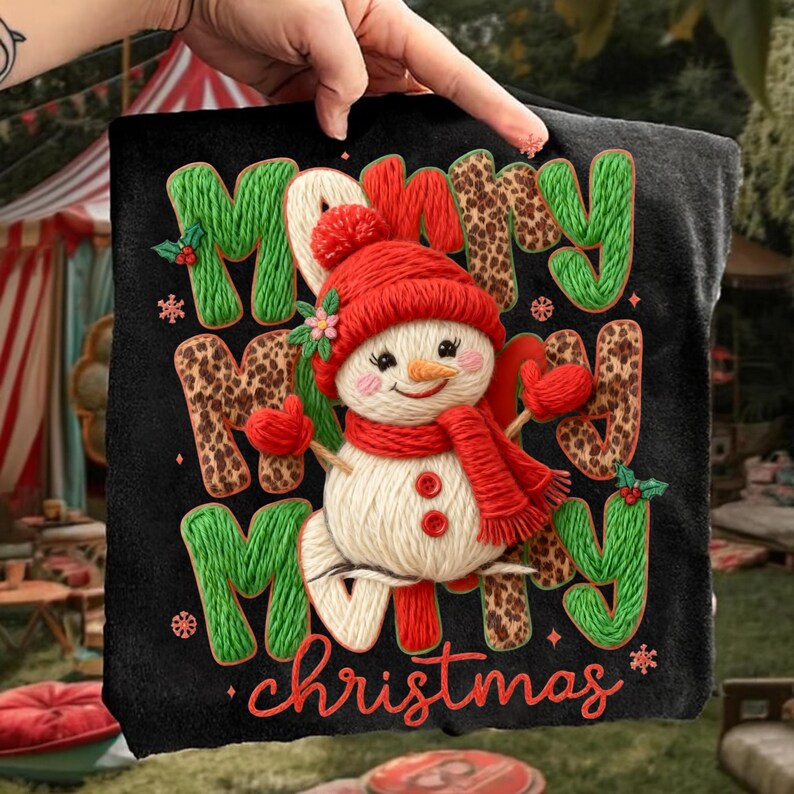 May include: Black t-shirt with a snowman design. The snowman wears a red hat, scarf, and mittens. The words "Merry Christmas" are displayed in green and leopard print letters with red accents. A festive holiday design.