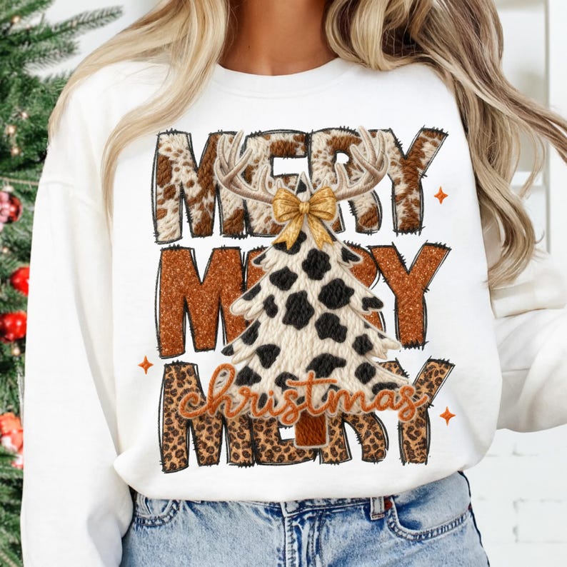 May include: White sweatshirt with a festive "Merry Christmas" design. The design features the words "Merry Christmas" in a mix of brown, leopard print, and cow print patterns, with a Christmas tree and antlers.