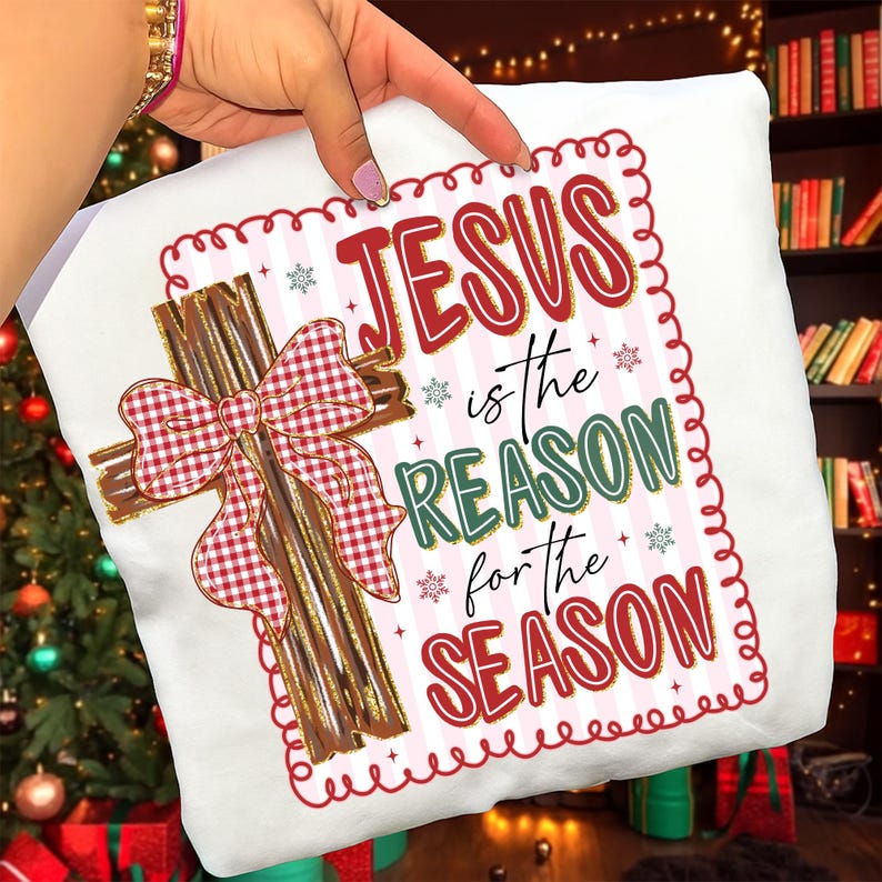May include: White pillow with a Christmas theme. The pillow features a cross made of wooden slats with a red and white checkered bow. The text "JESUS is the REASON for the SEASON" is printed on the pillow in red and green.