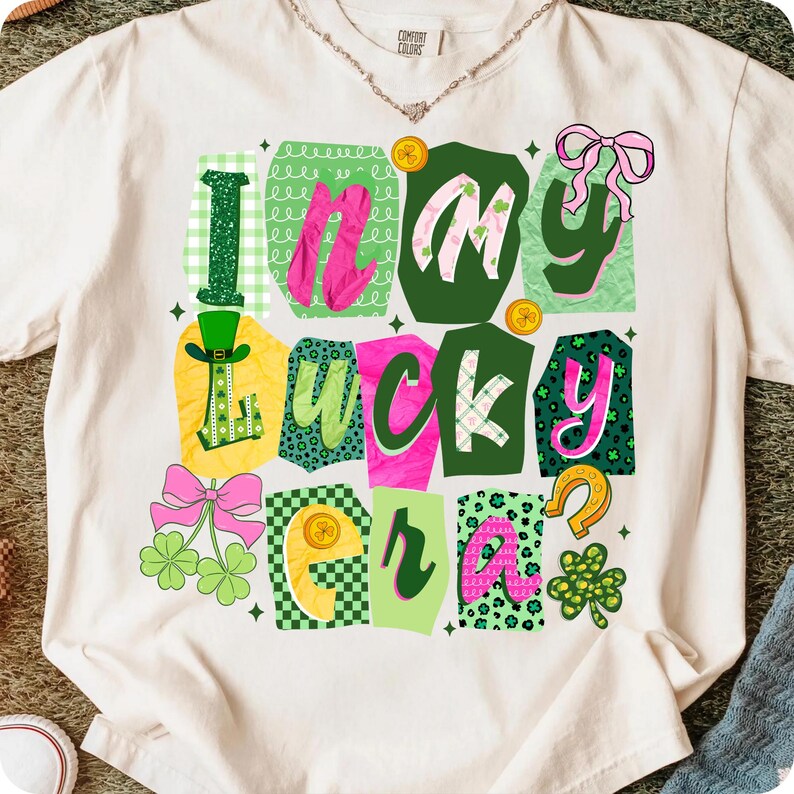 May include: Cream-colored t-shirt with the phrase "In My Lucky Era" in a colorful, patchwork design. The design includes green, pink, and yellow elements, such as shamrocks, a horseshoe, and a leprechaun hat, perfect for St. Patrick's Day.