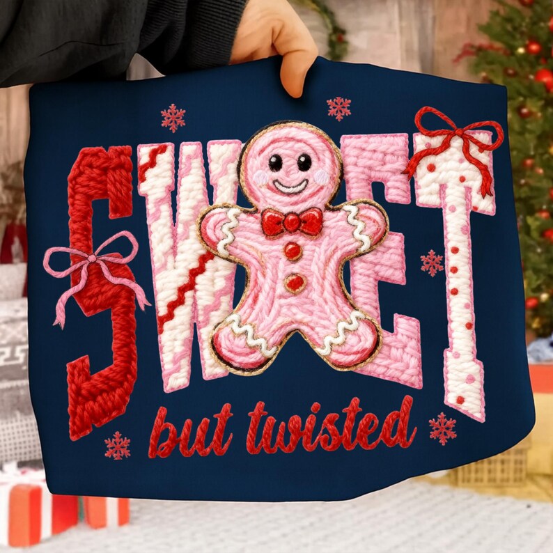 May include: A navy blue pillow with the words "SWEET but twisted" in red and pink yarn. A pink gingerbread man with a red bow tie is in the center. Snowflakes and bows are also featured in the design.