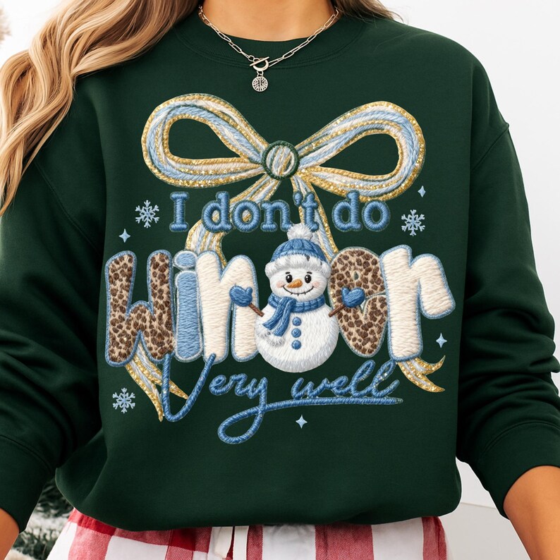 May include: Dark green sweatshirt with a whimsical design. The graphic features a snowman wearing a blue hat and scarf, with the text "I don't do winter very well." The word "winter" has a leopard print pattern. A large bow and snowflakes complete the design.