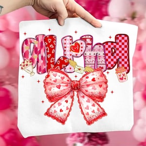 May include: White tote bag with the word "ALL YOU NEED" in pink and red letters. The letters have heart and floral patterns. A large red bow with heart details is at the bottom. Valentine's Day themed.