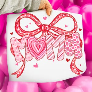 May include: A white sheet with the word "MIMI" in pink and red, decorated with hearts and a bow. The letter "M" is patterned with hearts, the "I" is a heart shape, and the other "M" is striped. The "I" is checkered.