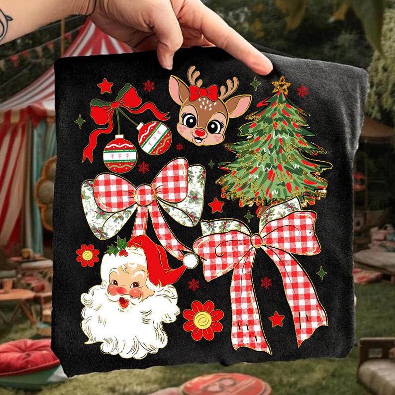 May include: Black t-shirt with festive Christmas graphics. The design includes a reindeer with a red bow, a decorated Christmas tree, Santa Claus, red and white checkered bows, baubles, and red stars and flowers.