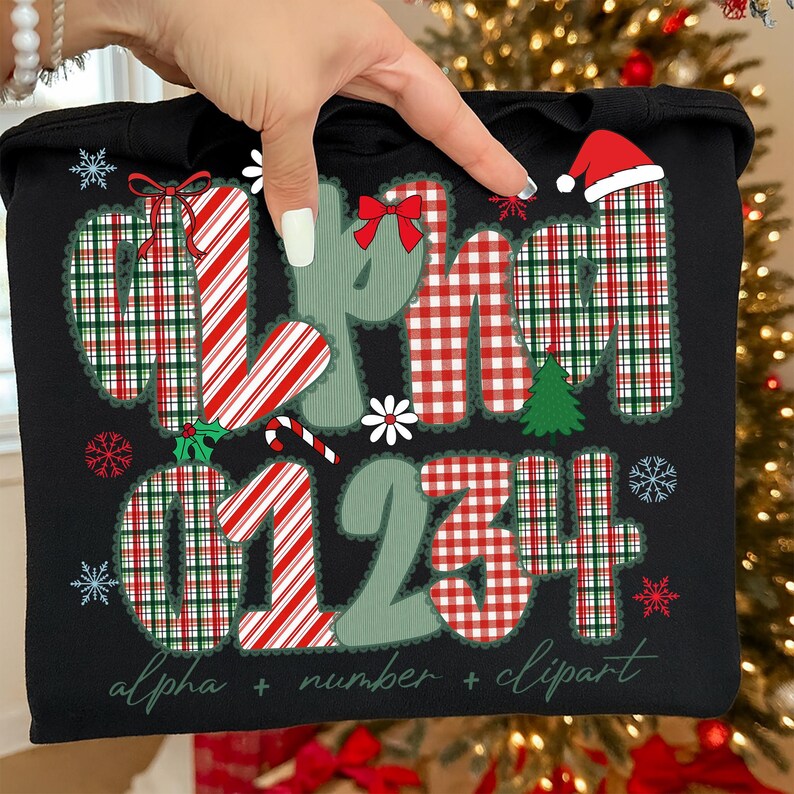 May include: Black tote bag with a Christmas-themed design. The design includes the words "alpha," "number," and "clipart," along with the numbers "01234." The letters and numbers are decorated with red and green plaid patterns, candy cane stripes, and snowflakes.