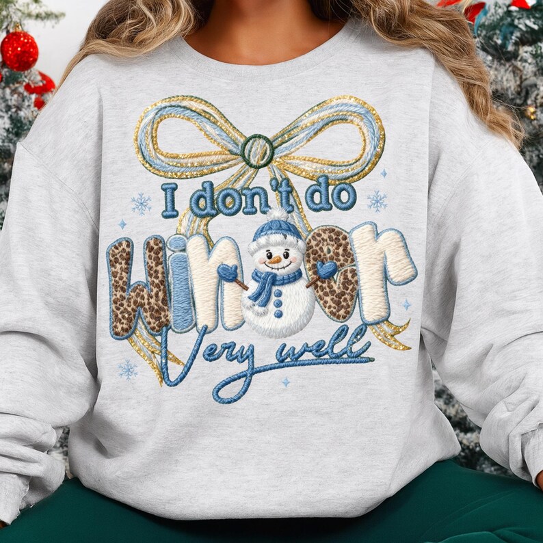 May include: A light gray sweatshirt with the phrase "I don't do winter very well." The word "winter" has a leopard print pattern. A snowman graphic is in the center, wearing a blue hat and scarf. A large bow is at the top.