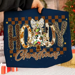 May include: Navy blue Christmas-themed design featuring the words "HO HOY Christmas" in a mix of leopard and cow print. A Christmas tree with lights and a bow is in the center. Brown and gold accents with a checkered pattern.
