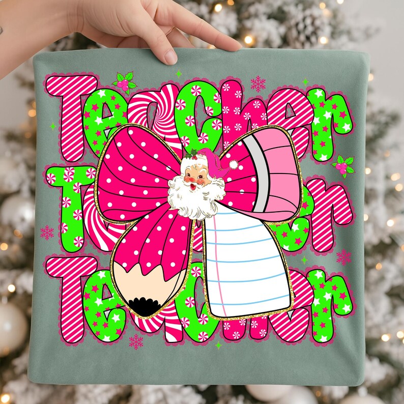 Peut inclure: Un coussin vert clair avec le mot "Teacher" en grandes lettres color&eacute;es. Le motif comprend un n&oelig;ud rose &agrave; pois blancs, une illustration du P&egrave;re No&euml;l et un crayon. Les lettres sont soulign&eacute;es en rose et vert avec des &eacute;toiles et des flocons de neige.
