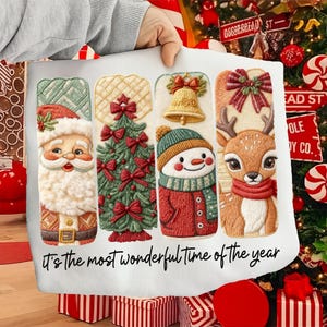 May include: A white Christmas-themed pillowcase featuring embroidered designs of Santa Claus, a Christmas tree, a snowman, and a reindeer. The text "It's the most wonderful time of the year" is written in black script across the bottom.