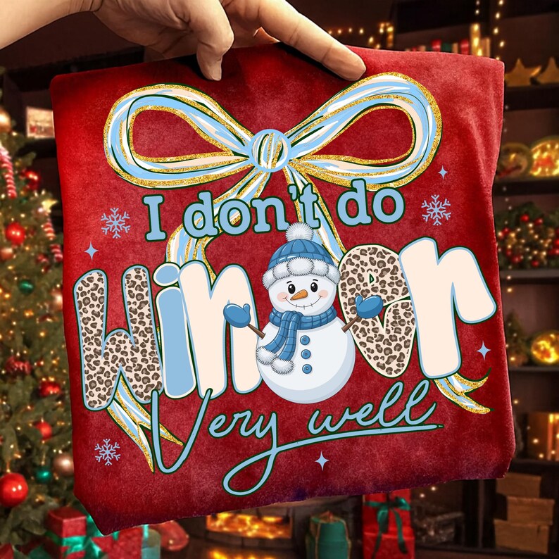 May include: Red Christmas-themed t-shirt with the text "I don't do winter very well." The design includes a snowman wearing a blue hat and scarf, and the word "winter" has a leopard print pattern. A large bow and snowflakes complete the design.