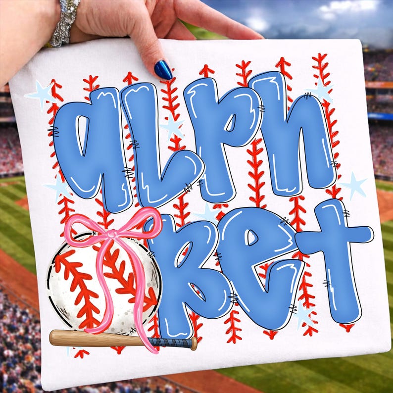 May include: White square with the word "ALPHABET" in large, light blue bubble letters. A baseball with a pink bow and a small wooden bat are featured below the text. Red stitching and blue stars decorate the background.