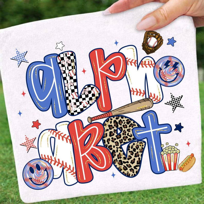 Op de afbeelding: Witte handdoek met de woorden "ALPHABET" en "BASEBALL" in rood, blauw en zwart. De letters zijn versierd met honkballen, luipaardprint en dambordpatronen. Inclusief honkbalhandschoen, knuppel en smiley gezichten.