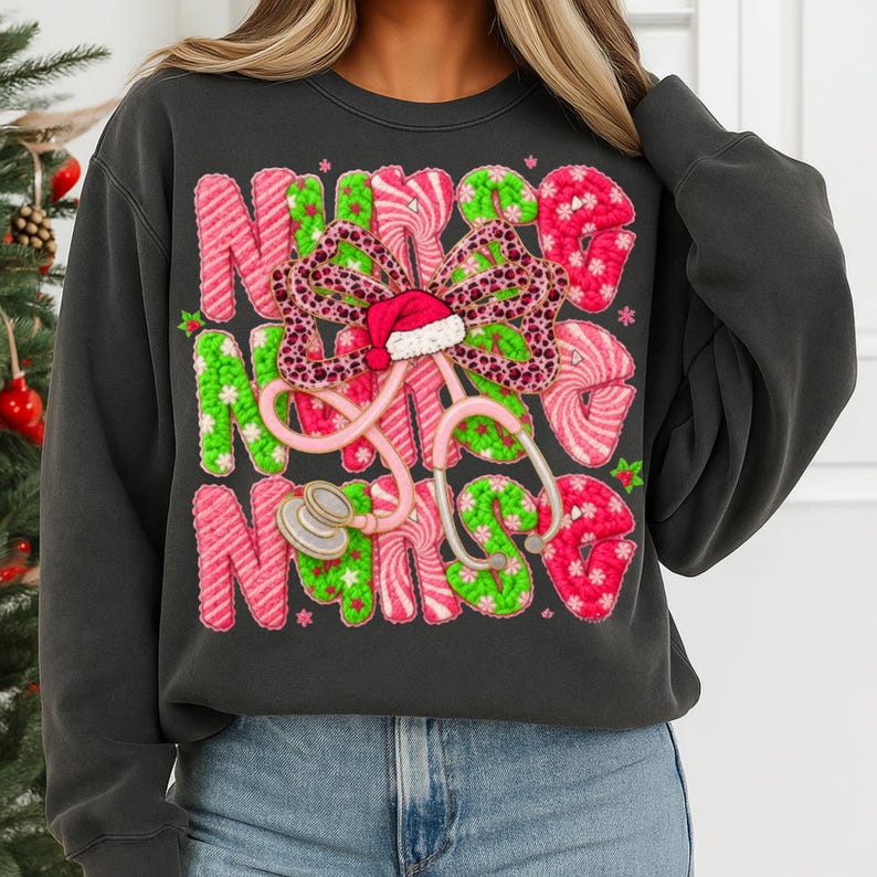 May include: Dark gray sweatshirt with the word "NURSE" in pink and green candy cane-style letters. A stethoscope and a bow with a Santa hat are in the center. The sweatshirt is a festive holiday design.