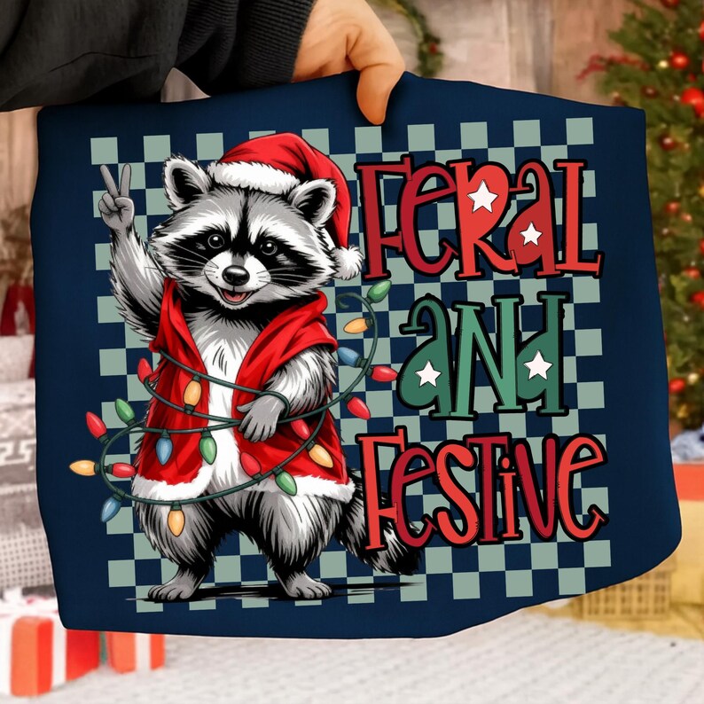 May include: A navy blue square Christmas-themed design featuring a raccoon wearing a Santa hat and red vest, holding a string of lights. The text "FERAL AND FESTIVE" is displayed in red and green with white stars.