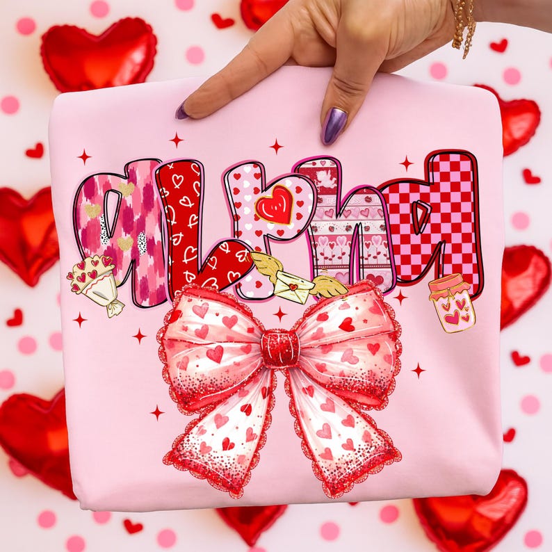 May include: A pink sweatshirt with the name "ALEXA" in a decorative font, featuring hearts, patterns, and a large bow. The bow is red and white with heart details. Additional elements include a bouquet, a jar, and an envelope with wings.