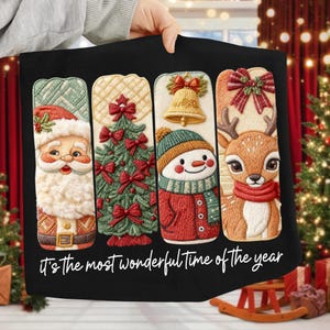 May include: Black Christmas-themed pillow with embroidered designs of Santa Claus, a Christmas tree, a snowman, and a reindeer. The pillow features the text "It's the most wonderful time of the year" in white script.