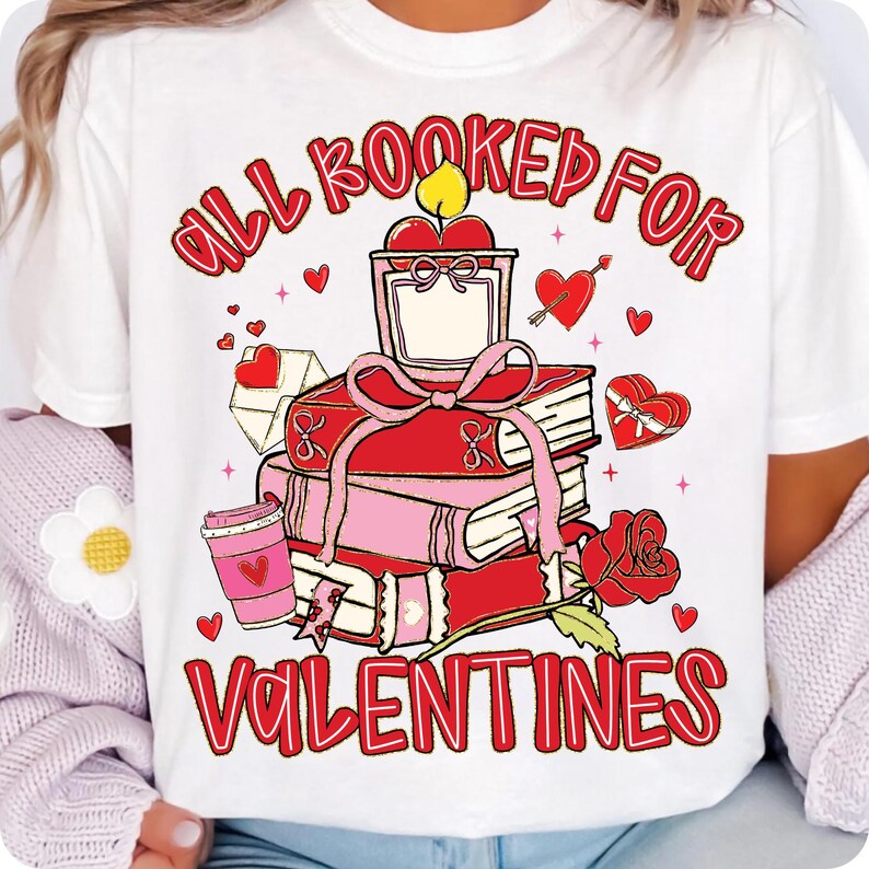 May include: White t-shirt with a Valentine's Day design. The graphic features a stack of books, a candle, a coffee cup, and a rose. The text reads "ALL BOOKED FOR VALENTINES" in red script.
