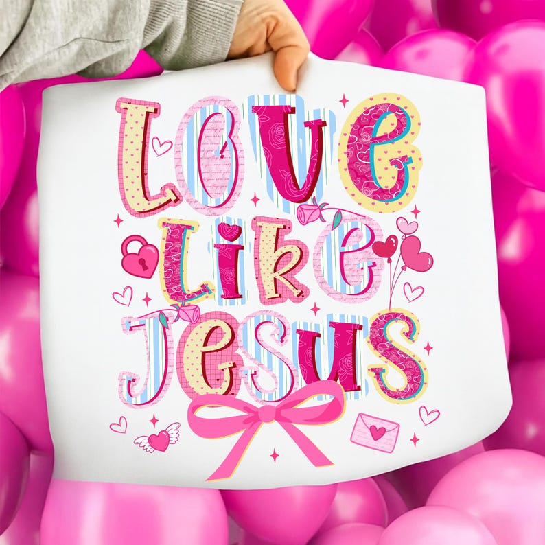 May include: A white print with the words "Love Like Jesus" in colorful, decorative lettering. The design includes hearts, a lock, a bow, and a rose, all in shades of pink, yellow, and blue.