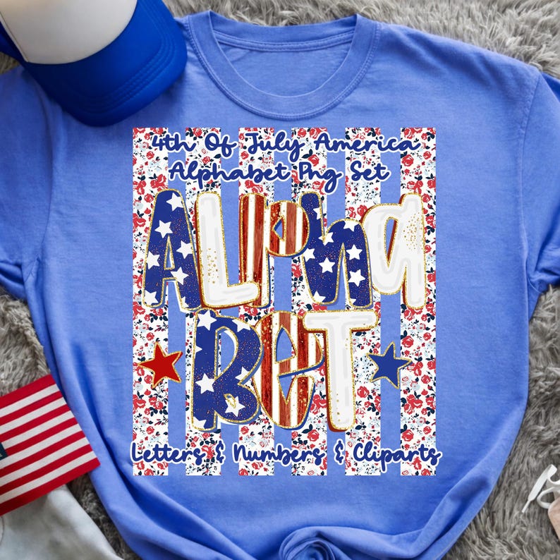 May include: A light blue t-shirt with a patriotic design. The design features the words "ALMOST BUT" in red, white, and blue, with stars and stripes. The shirt also includes the text "4th Of July America Alphabet Png Set".